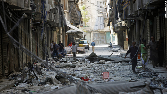 Residents walk down a street covered in rubble in the neighborhood of Bustan al-Basha on Saturday.
