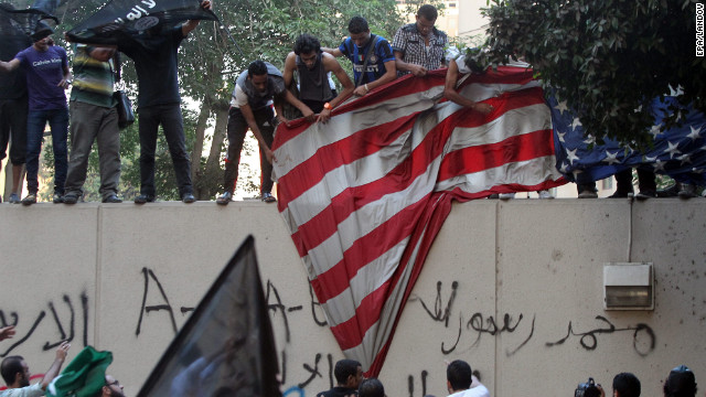 Protesters pull down a U.S. flag during a protest in front of the U.S. Embassy in Cairo on Tuesday, September 11. Islamists, angered by a film they say defames the prophet Mohammed, scaled the walls of the embassy to tear down the U.S. flag and raise a black flag in an unprecedented security breach.