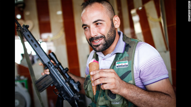 A member of the Free Syrian Army enjoys an ice cream on the road from Azaz to Aleppo on Monday.