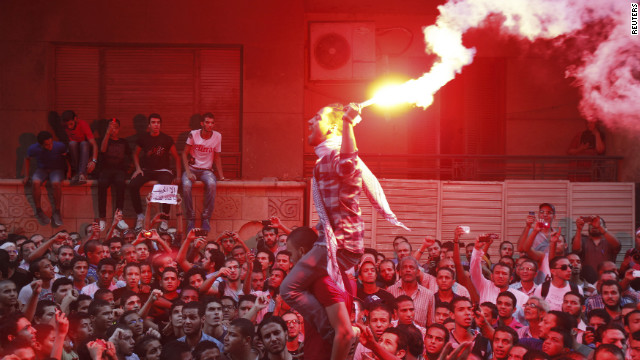 People shout slogans and light flares in front of the U.S. Embassy in Cairo.