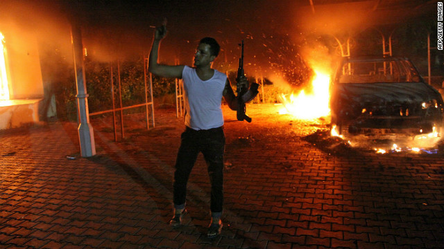 A man waves his rifle as buildings and cars are engulfed in flames inside the U.S. Consulate compound in Benghazi, Libya, late on Tuesday, September 11.