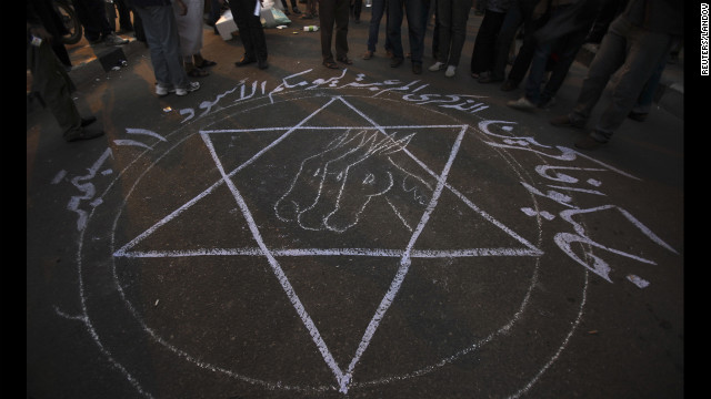 People stand around a drawing that says "Remember your black day 11 September" during the protest in Cairo.