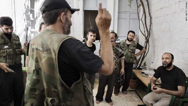 Syrian rebel commander Abu Mohammed, far right, listens to reports from fellow fighters at his base in the Old City neighborhood of Aleppo on Wednesday.
