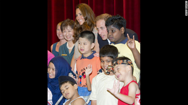 The duke and duchess pose for a picture with children as they visit The Rainbow Centre in Singapore. 