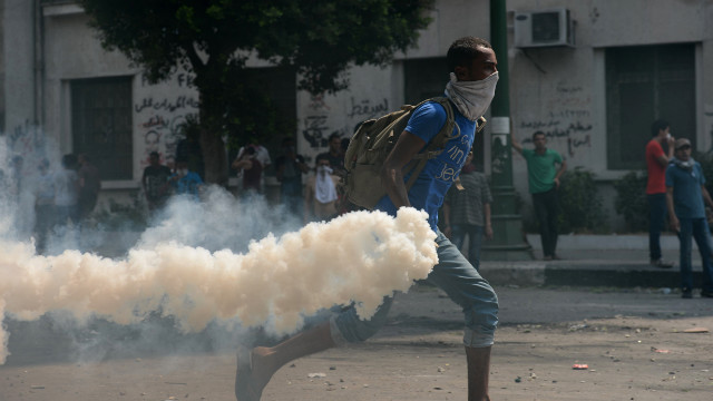 An Egyptian protester throws a tear gas canister at riot police Thursday during clashes near the U.S. Embassy in Cairo.