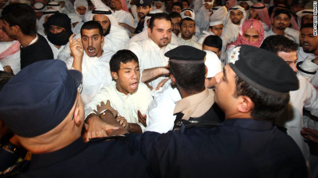 Kuwaiti police stand guard as hundreds of demonstrators protest near the U.S. Embassy in Kuwait City on Thursday.