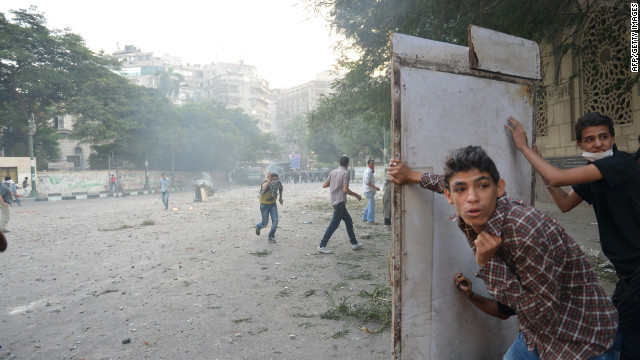 Egyptian protesters take cover during clashes with riot police on Thursday.