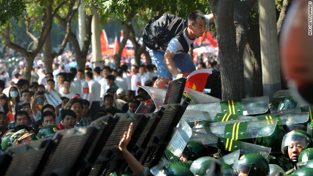 A protester tries to climb over a security barrier during an anti-Japanese protest outside its embassy in Beijing on September 15, 2012.