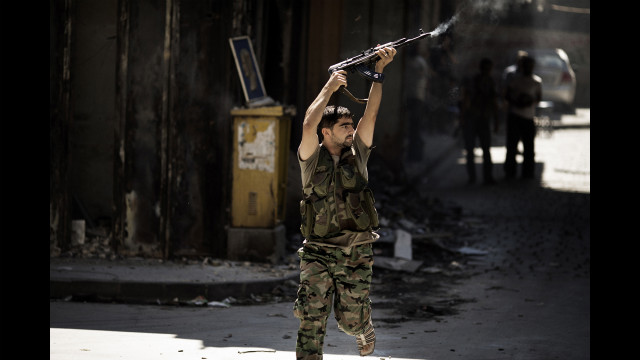 A Syrian rebel fires at a position held by regime forces during clashes on Friday in Aleppo.