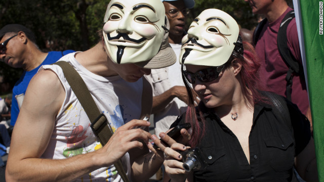 Occupy Wall Street protesters check their cell phones in Washington Square Park on Saturday.