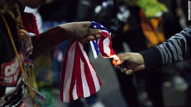 An Occupy Wall Street protester, who said she was not acting as part of the overall Occupy movement but as an individual, lights an American flag on fire during the march in New York City on Saturday.