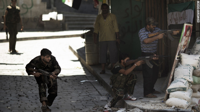 Syrian rebels prepare to fire during clashes with regime forces as they stand near a picture of Syrian President Bashar al-Assad used as a mock sniper target in Aleppo on Friday, September 14.