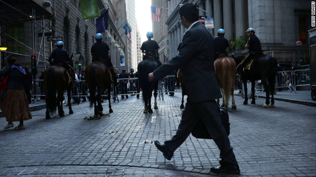 A man walks by a police blockade along Wall Street during Occupy Wall Street demonstrations on Monday.