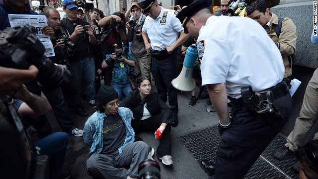 An officer warns people they will be arrested for blocking a sidewalk during the Occupy Wall Street protest on Monday, September 17, in New York.