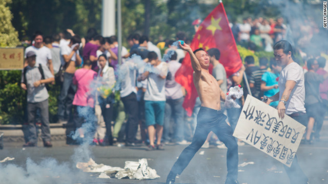  A protester hurls a gas cannister during a demonstration in Shenzhen, China on September 16, over the disputed Diaoyu Islands, which is also known as Senkaku by Japan.