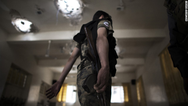 A Free Syrian Army fighter moves inside an artillery-shelled mosque Sunday in Aleppo.