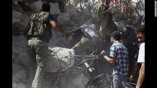 People pull out bodies from under the rubble of a destroyed building in Aleppo on Wednesday.