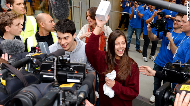 Tamsyn Vohradsky holds up her iPhone 5 after becoming the first buyer of Apple's new smartphone at a store in Sydney, Australia, on Friday, September 21.