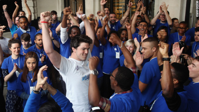 Ryan Williams, 22, of Kent, is cheered by Apple employees as he is let into the Apple Store in London, becoming the first to purchase the iPhone 5 smartphone in London on Friday.