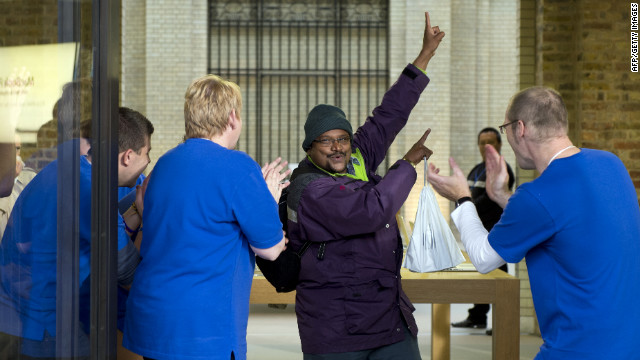 Apple Store employees applaud a customer after his new purchase. 