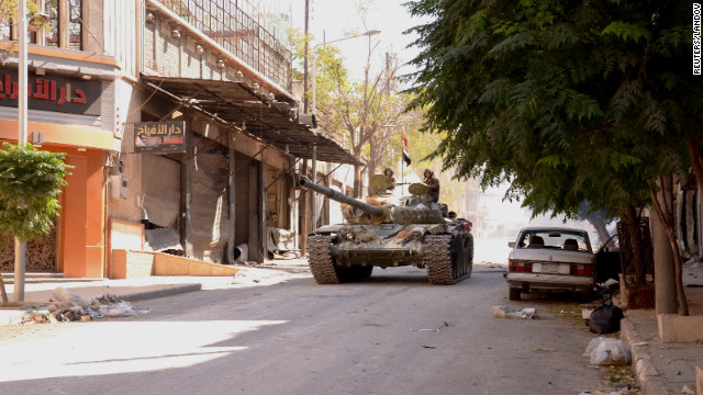 Soldiers loyal to President Bashar al-Assad travel in a Syrian Army tank in Aleppo on Sunday, September 23, after clashes between Free Syrian Army fighters and regime forces.