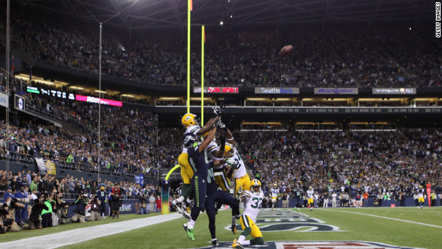 Seahawks wide receiver Golden Tate, in navy blue, jumps for the ball, surrounded by Green Bay players. Before he made the catch in the end zone, Tate shoved Packers defender Sam Shields in the back, which would typically draw an offensive pass interference penalty.