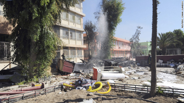 Firefighters stand among debris from the destroyed school building in Damascus on Tuesday.