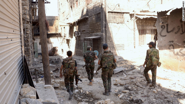 Syrian troops walk down a street Tuesday, September 25, in Aleppo following fighting between government forces and rebels.