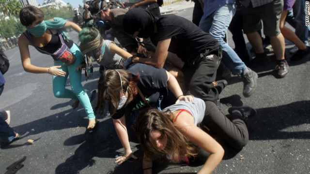 Protesters fall down in the street during clashes on Wednesday.