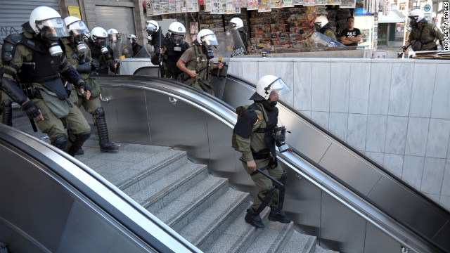 Police chase rioting youths at a subway entrance in the center of Athens Wednesday.