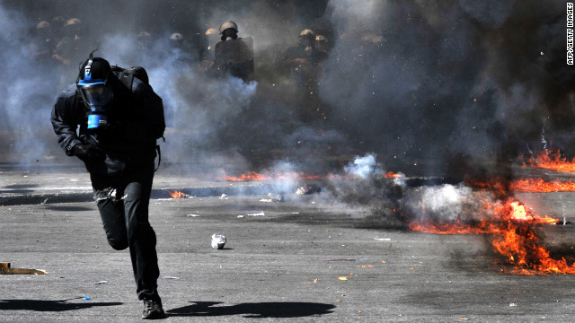 A protester runs from riot police Wednesday.