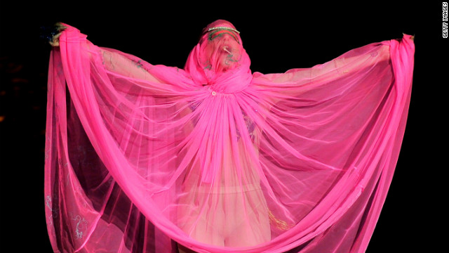 Lady Gaga drapes herself in pink on the catwalk at the Philip Treacy fashion show.