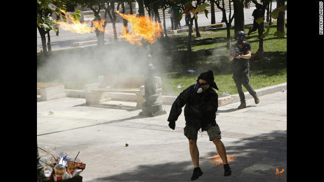 A demonstrator throws a Molotov cocktail at riot police near Syntagma Square on Wednesday.