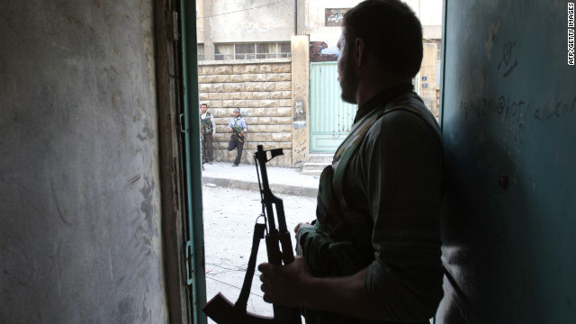 A rebel fighter looks out a doorway during fighting in Aleppo on Thursday.