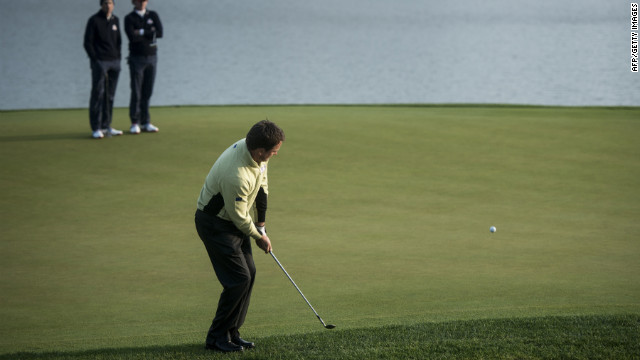 Team Europe's Graeme McDowell chips onto the second hole's green Friday.