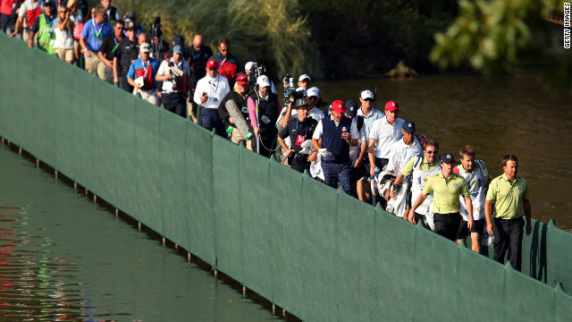 McIlroy and McDowell walk across a bridge ahead of the gallery on Friday.