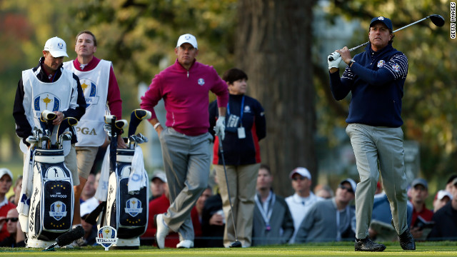 American Phil Mickelson watches his tee shot on the fourth hole as Lee Westwood of Europe looks on.