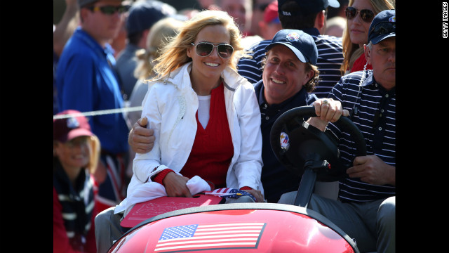 Phil Mickelson of the United States drives with his wife Amy Mickelson on the 16th green.