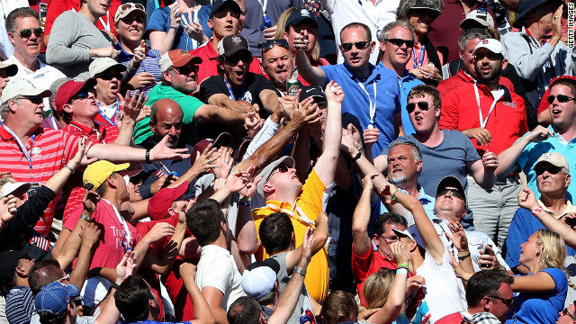 Fans reach for a golf ball Sunday on the 17th green.