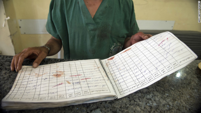 A doctor looks at the register of dead people, stained with blood, in a hospital in the eastern sector of the city of Aleppo on October 1, 2012.