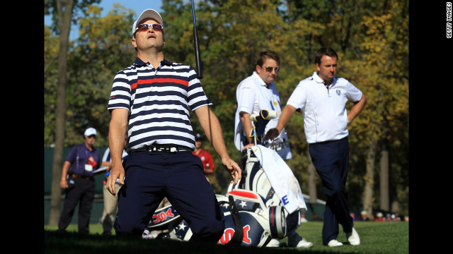 Zach Johnson of the United States reacts to a shot on the ninth hole Sunday as Graeme McDowell, right, and his caddie, Ken Comboy, of Europe look on.