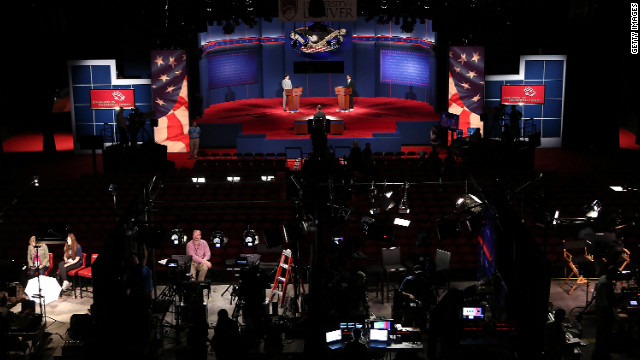 As members of the media prepare their television sets, University of Denver students Zach Gonzales, left, and Dia Mohamed stand in for the nominees during a dress rehearsal for the presidential debate Tuesday, October 2, in Denver. President Obama and Mitt Romney will square off during the first of three debates on Wednesday night. 