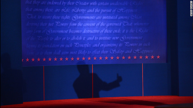 Romney's shadow is projected beneath text from the Declaration of Independence at the University of Denver's Magness Arena.
