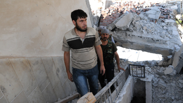 Rebels climb the stairs of a destroyed building Thursday in Tal Abyadh.