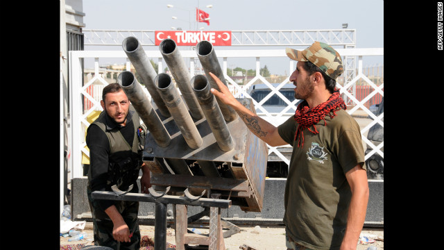 Syrian rebel fighters look at a multirocket launcher in Tal Abyadh, a Syrian town close to the Turkish border, on Thursday, October 4. Tensions rippled across Turkey a day after Syrian shelling struck a Turkish border town and killed five people. <a href='http://www.cnn.com/SPECIALS/world/photography/index.html'>See more of CNN's best photography</a>.
