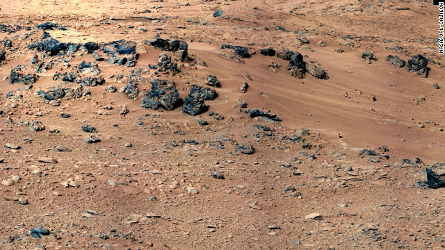 An area of windblown sand and dust downhill from a cluster of dark rocks has been selected as the likely location for the first use of the scoop on the arm of NASA's Mars rover Curiosity. 