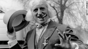 Jimmy Savile sports his Order of the British Empire medal after his 1972 investiture at Buckingham Palace in London.