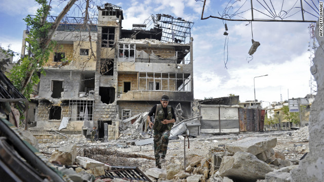 A Syrian rebel runs across a heavily damaged street to dodge sniper fire during clashes on Saturday.