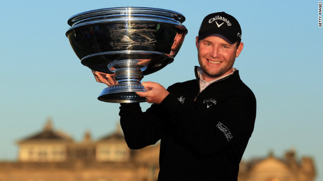 Branden Grace holds the winning trophy aloft after claiming victory in the Dunhill Links Championship.