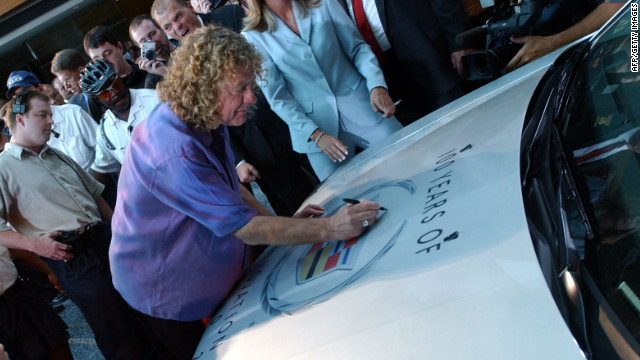 Lead singer Plant autographs the hood of a Cadillac CTS in Detroit in 2002. Led Zeppelin's music has been featured in Cadillac commercials.